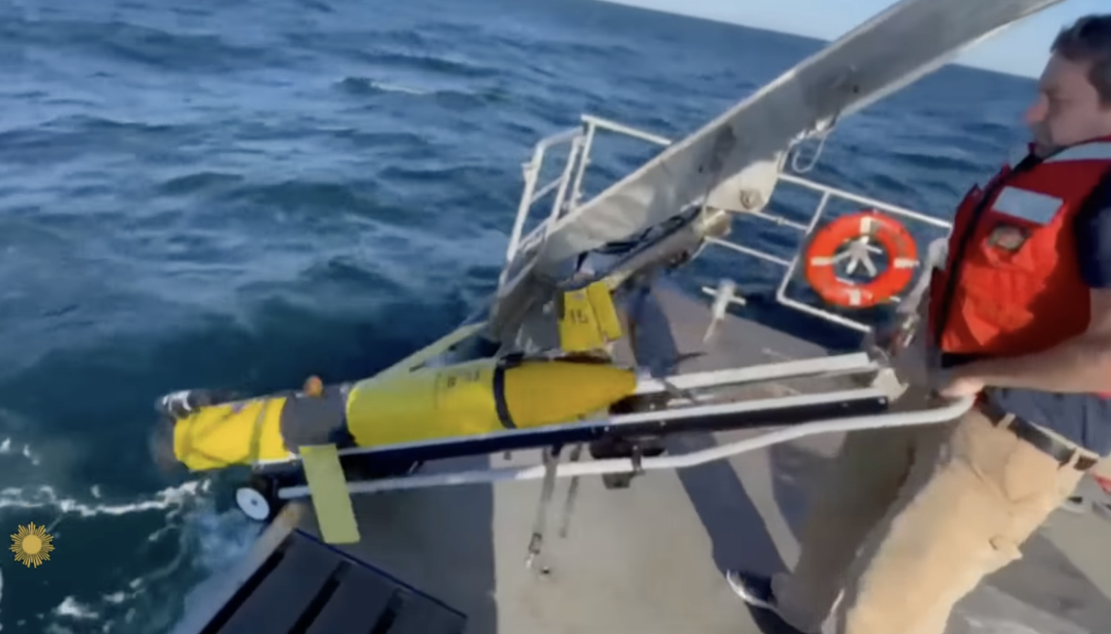 Yellow AUV being slide down a ramp to launch into the ocean